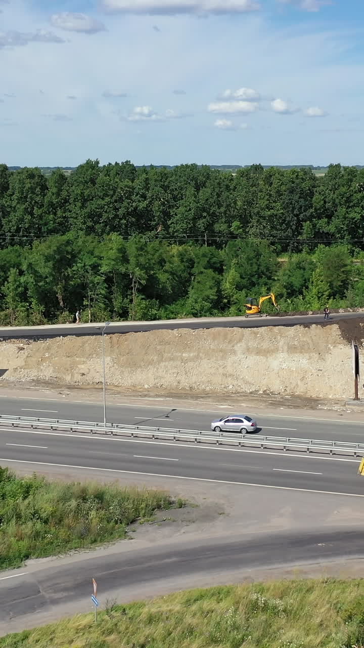 Asphalt road under construction. Aerial view aboveroad construction worker, view from drone Vertical video
