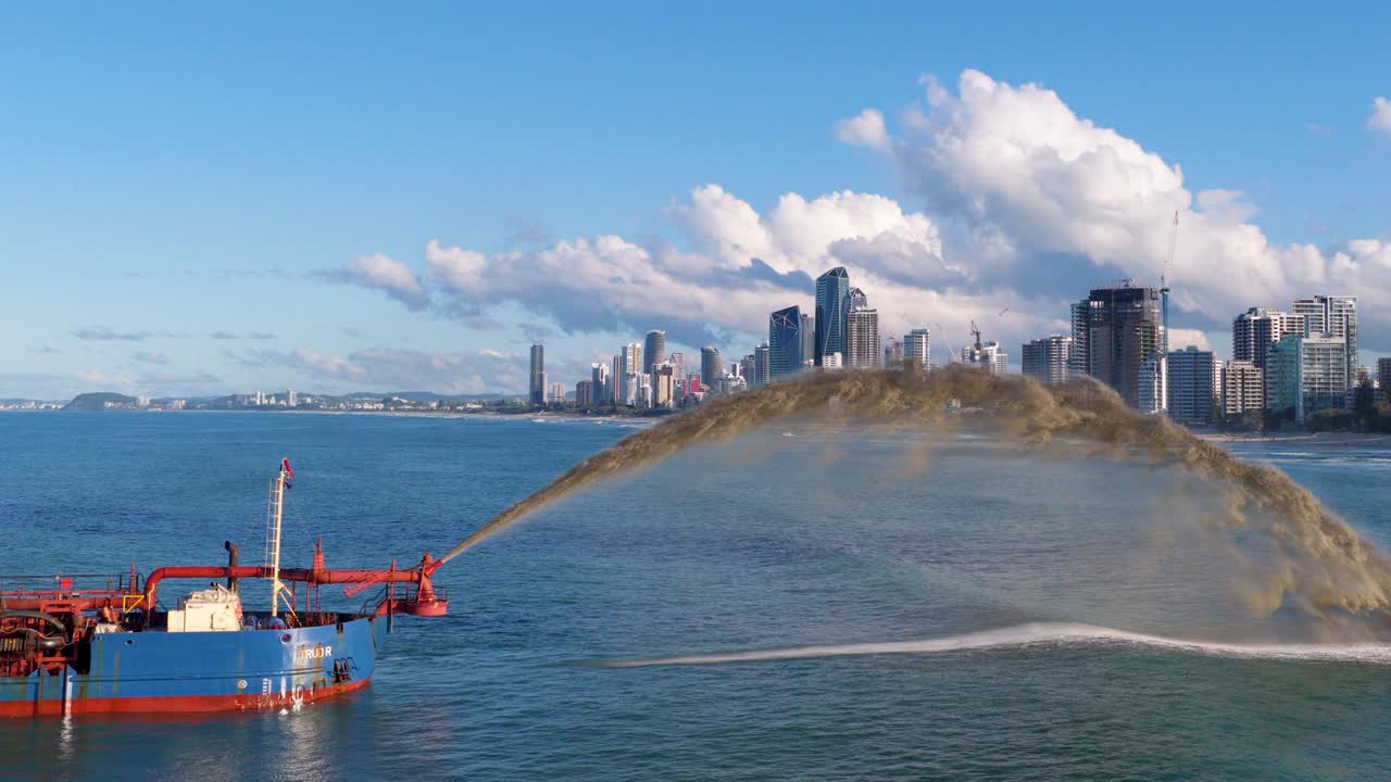 Aerial footage of sand dredging near Gold Coast cityscape, showcasing dynamic water and sand movement under clear skies