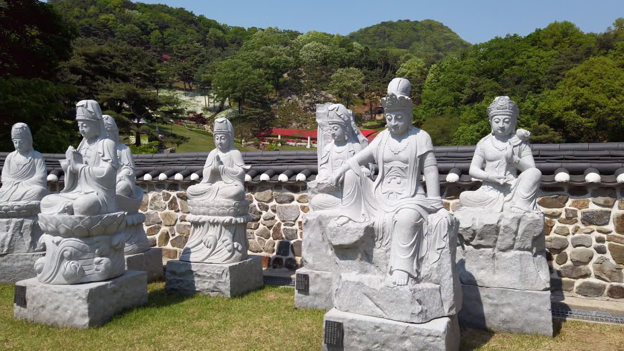 Stone Buddhist Statues in a Temple Garden with Mountains in the Background