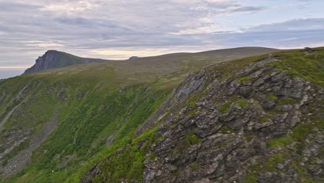 stave noruega aérea v6 vista panorámica lejos del océano atlántico norte, dron vuela alrededor de la ladera de la montaña capturando los detalles de la montaña escarpada cubierta de musgo verde - filmada con mavic 3 cine - junio de 2022