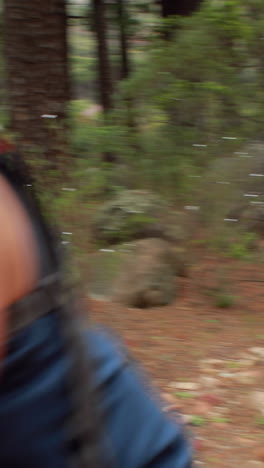 man biking through a forest