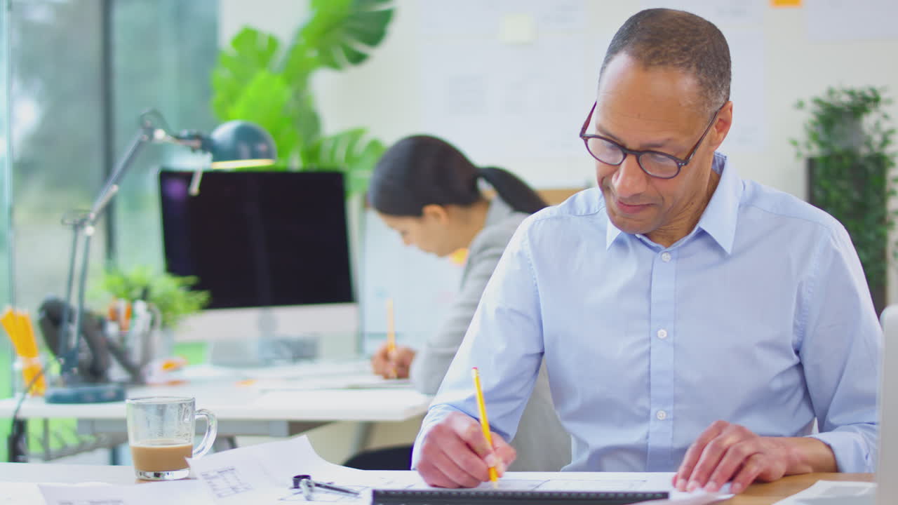 arquitectos masculinos y femeninos trabajando en la oficina en escritorios en planes para nuevos edificios
