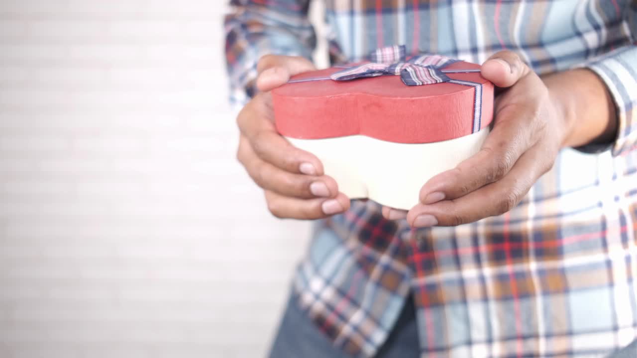 심장 모양 의 선물 상자 를 들고 있는 남자