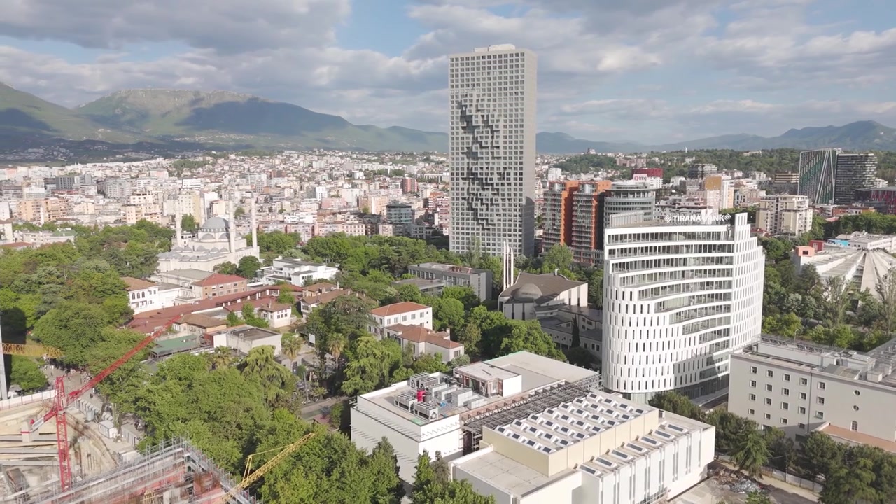 Aerea - Skyline di Tirana con torri moderne, minareti di moschee e cantieri edili in Albania.