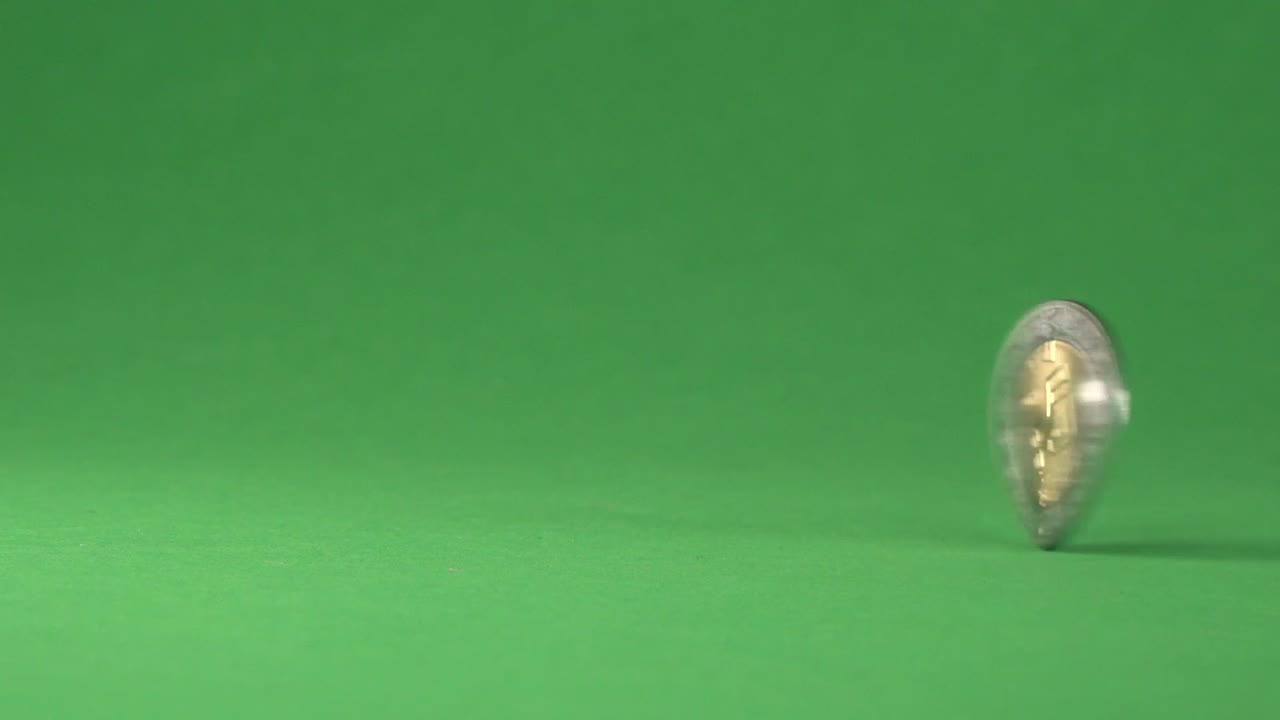 A Mexican coin of five pesos spinning on a chroma background