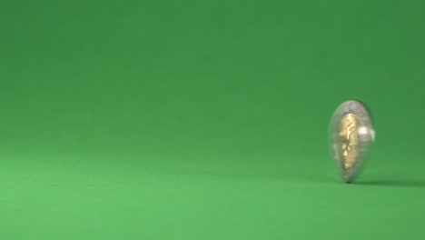 a mexican coin of five pesos spinning on a chroma background