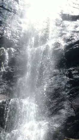 agua que fluye por una cascada de bosque rocoso