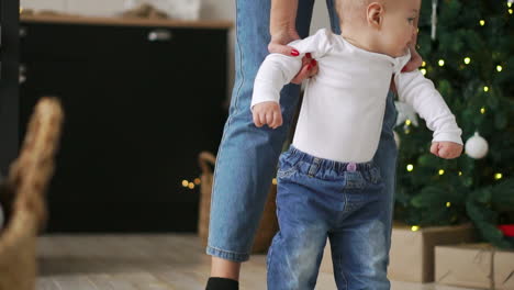 Closeup-of-mothers-and-baby's-feet-walking-on-wooden-floor-at-long-hallway