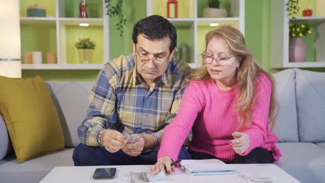 una pareja de jubilados preocupados calculando facturas comprobando el pago de préstamos bancarios pagando impuestos de deuda impagados.