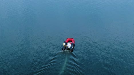 a red motorboat leading the canoe