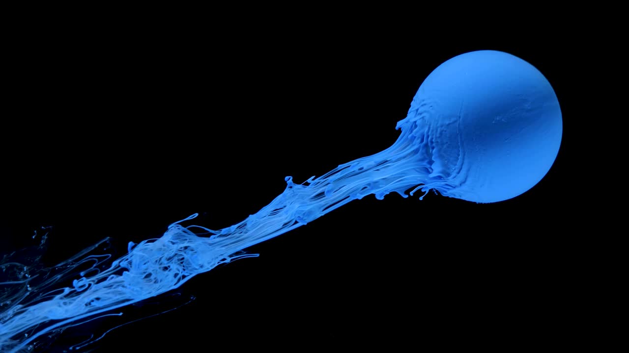 다채로운 잉크 페인트가 천천히 공에서 흘러나옵니다.