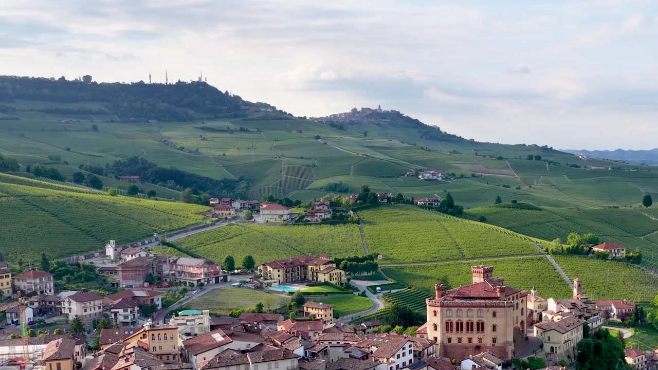 Drone sorvola lo storico borgo di Barolo e le dolci colline verdi dei vigneti in Italia.