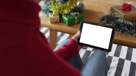 hombre caucásico con sombrero de santa haciendo llamada de video de navidad de tableta, copia espacio en la pantalla
