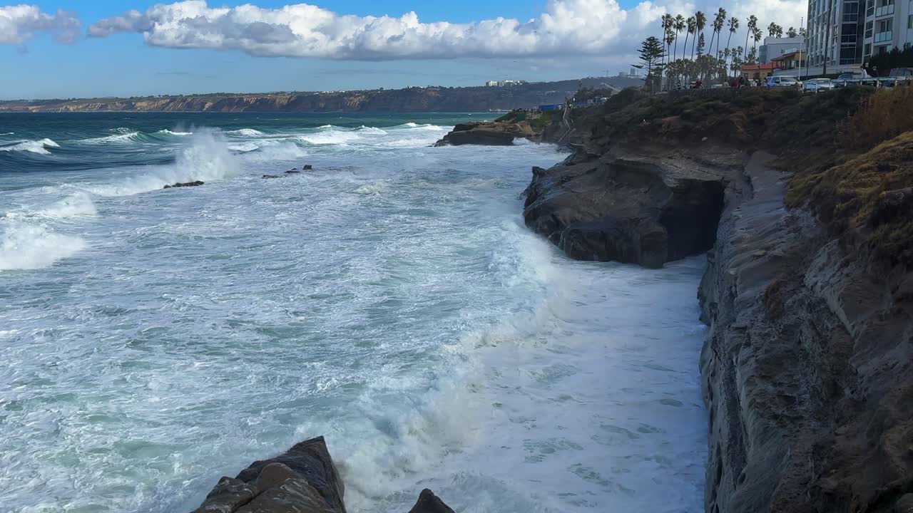 King tide at La Jolla Cove skyline view over waves crashing on cliffs