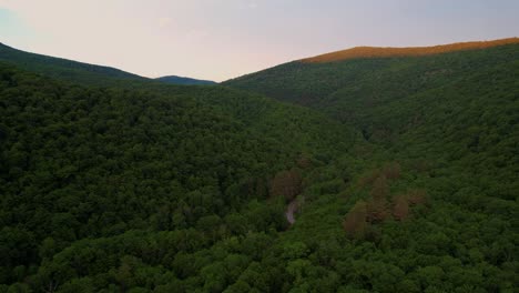 stunning drone video footage of a stunning appalachian mountain valley during summer at sunset with beautiful golden light