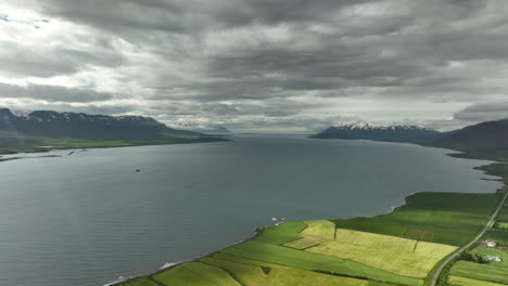 Northern-fjord-in-Iceland-snowy-mountain-farmlands-aerial-shot