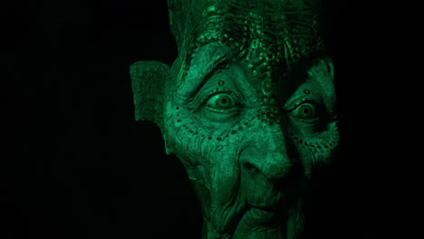 Mystical-Witch-demon-wooden-face-mask-covered-by-disturbing-green-light,-ancient-future-esthetics