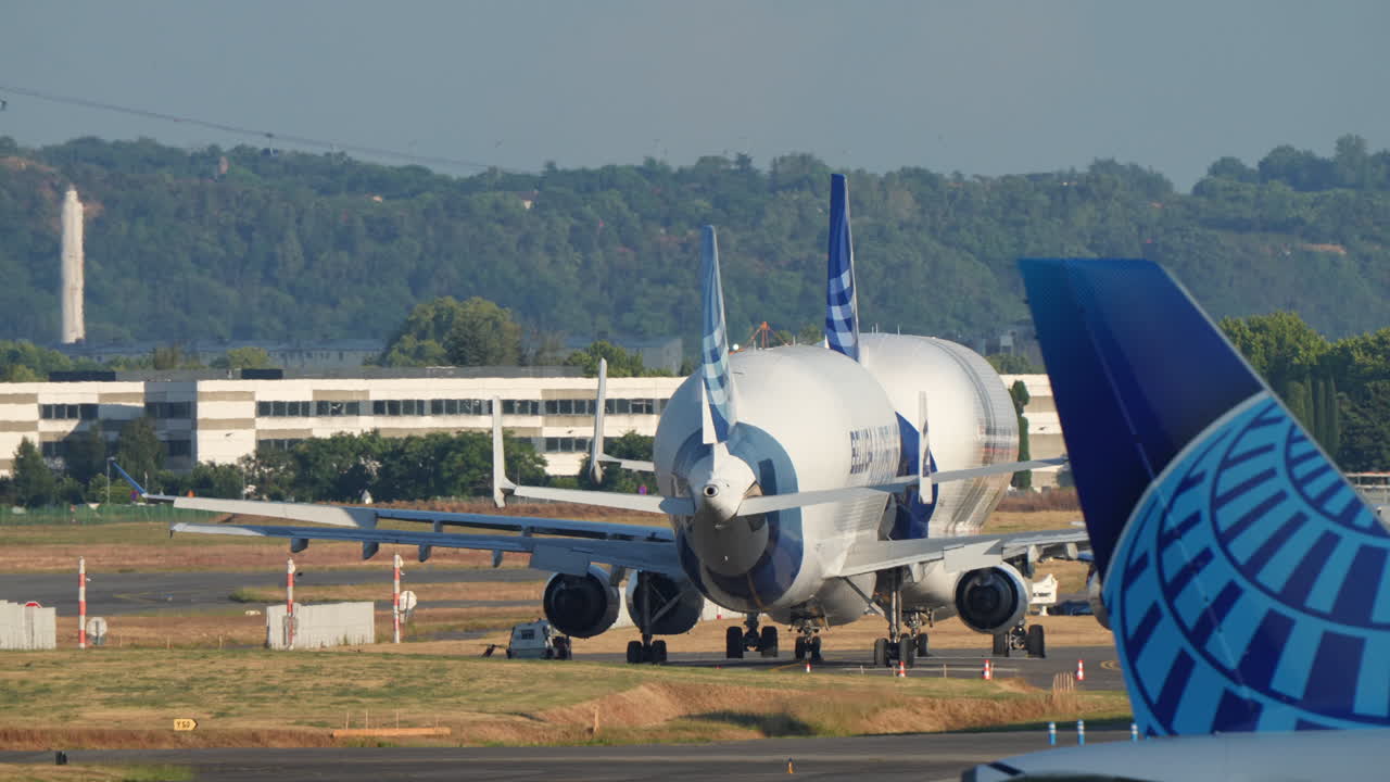 TOULOUSE, FRANCE - AUGUST 1, 2025: Airbus Beluga aircraft parked at Toulouse-Blagnac Airport with other aircraft and ground equipment visible in the background