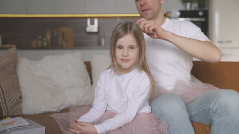 Papá-Peinando-El-Cabello-De-Su-Pequeña-Hija-En-Casa