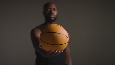 Studio-Portrait-Shot-Of-Male-Basketball-Player-Holding-Ball-Towards-Camera-1