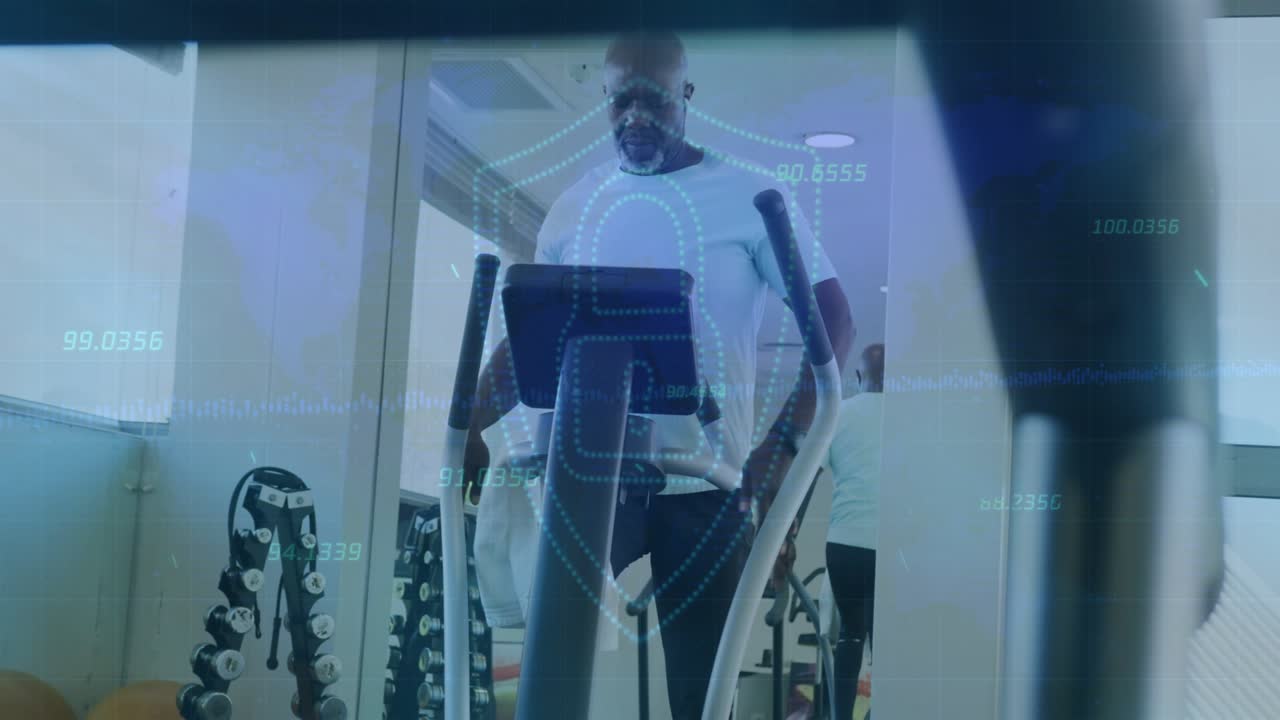 Mature man pedaling elliptical, wiping towel, leaning and checking console, tracking fitness stats