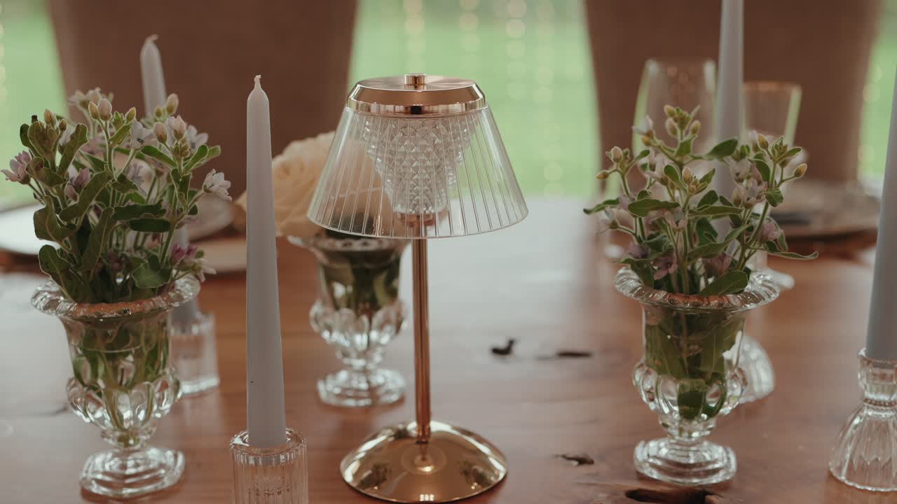 Beautiful wedding table setup with flowers, candles, and gold lamp