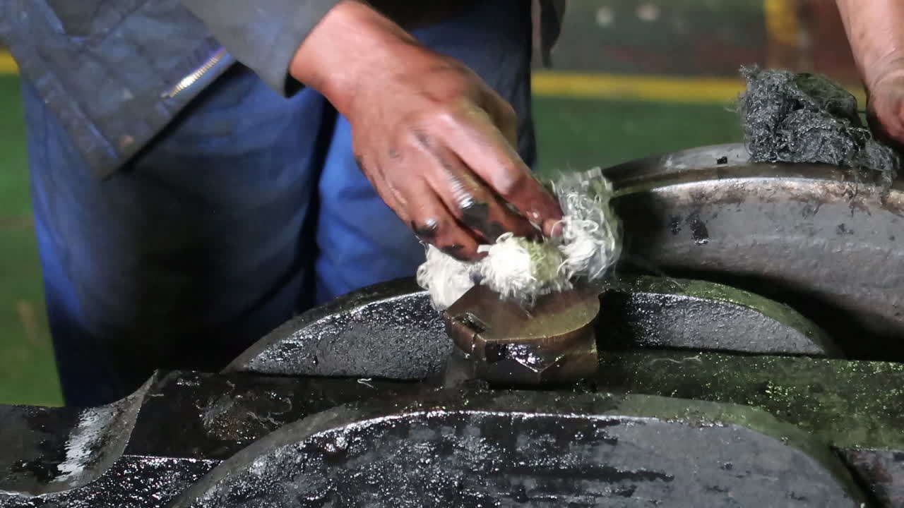 el hombre limpia la suciedad y la grasa de la escotilla en equipos industriales pesados, primer plano
