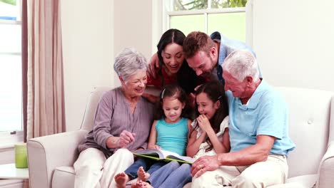 Lächelnde-Familie,-Die-Gemeinsam-Ein-Buch-Auf-Dem-Sofa-Liest