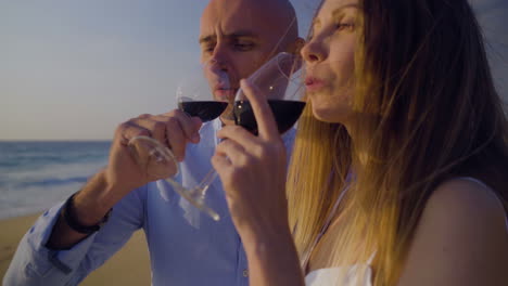 couple drinking red wine and looking at sea