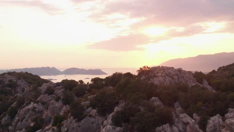 Beautiful-fiery-sunset-over-the-rocky-mountain-shoreline-of-Turkey--aerial