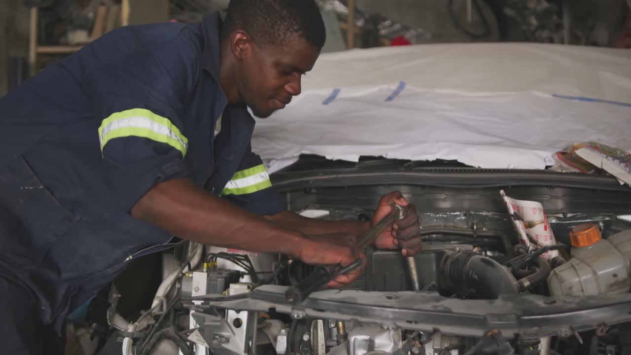 hombre africano reparando un coche