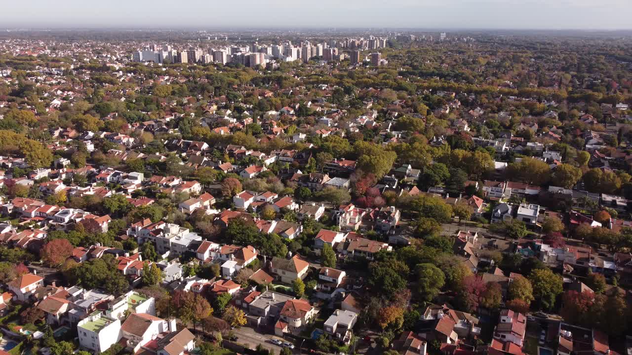 sobrevuelo aéreo zona residencial rural en buenos aires con árboles verdes y complejo de bloques en segundo plano