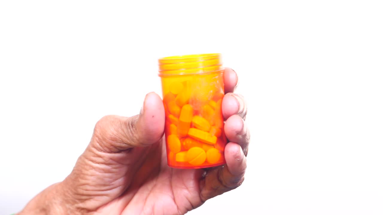 mano con una botella de pastillas