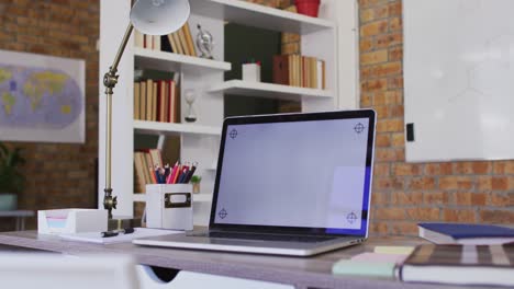 vista de la computadora portátil y otros suministros escolares en la mesa en el aula de la escuela
