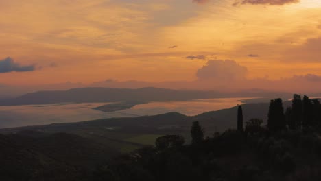 Imágenes-Aéreas-De-Drones-De-La-Icónica-Laguna-De-Monte-Argentario,-Frente-Al-Antiguo-Casco-Antiguo-De-Orbetello-Cerca-Del-Parque-Natural-Maremma-En-Toscana,-Italia-Con-Nubes-Dramáticas-Que-Cubren-El-Cielo-Al-Amanecer