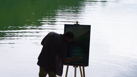 Painter silhouette against the lake.