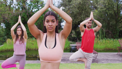 Grupo-Diverso-De-Hombres-Y-Mujeres-Practicando-Yoga,-Parados-Sobre-Una-Pierna-En-El-Parque