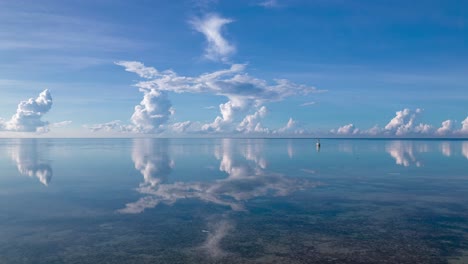 Drone-flying-low-over-waters-of-beautiful-lagoon-with-stunning-reflection-of-moving-clouds