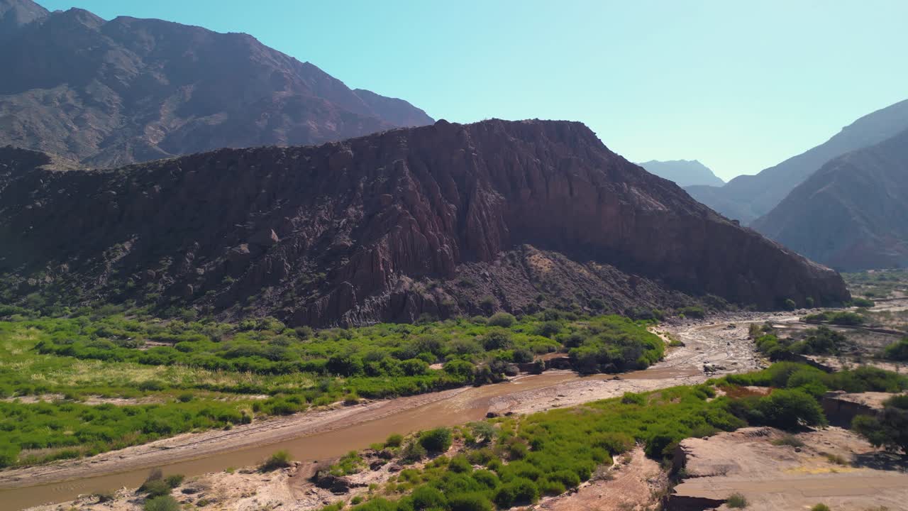 Vista aerea di un paesaggio montuoso arido con fiume e valle verde