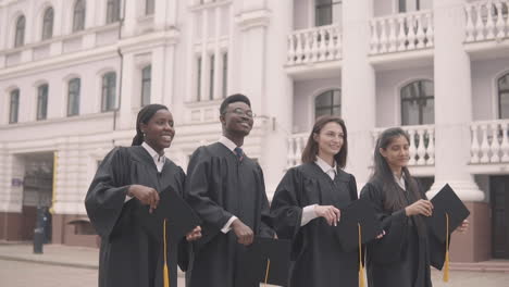 grupo multicultural de estudiantes graduados lanzando sus gorras al aire 1