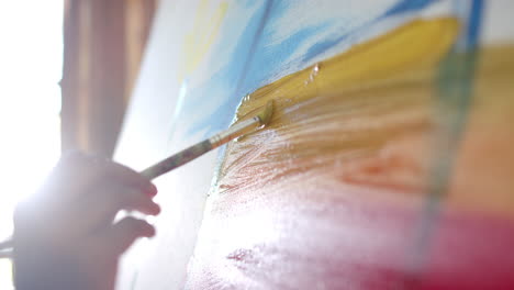 close up of senior biracial woman painting on big canvas at home, slow motion