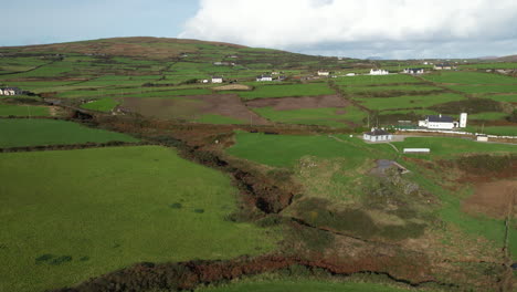 aerial view of irish landscape, green farming fields and meadows by village