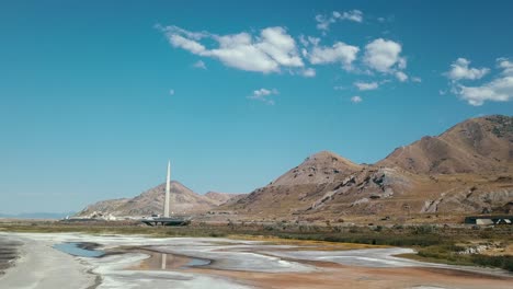 traffic on highway along arid mountains and tower under a blue sky