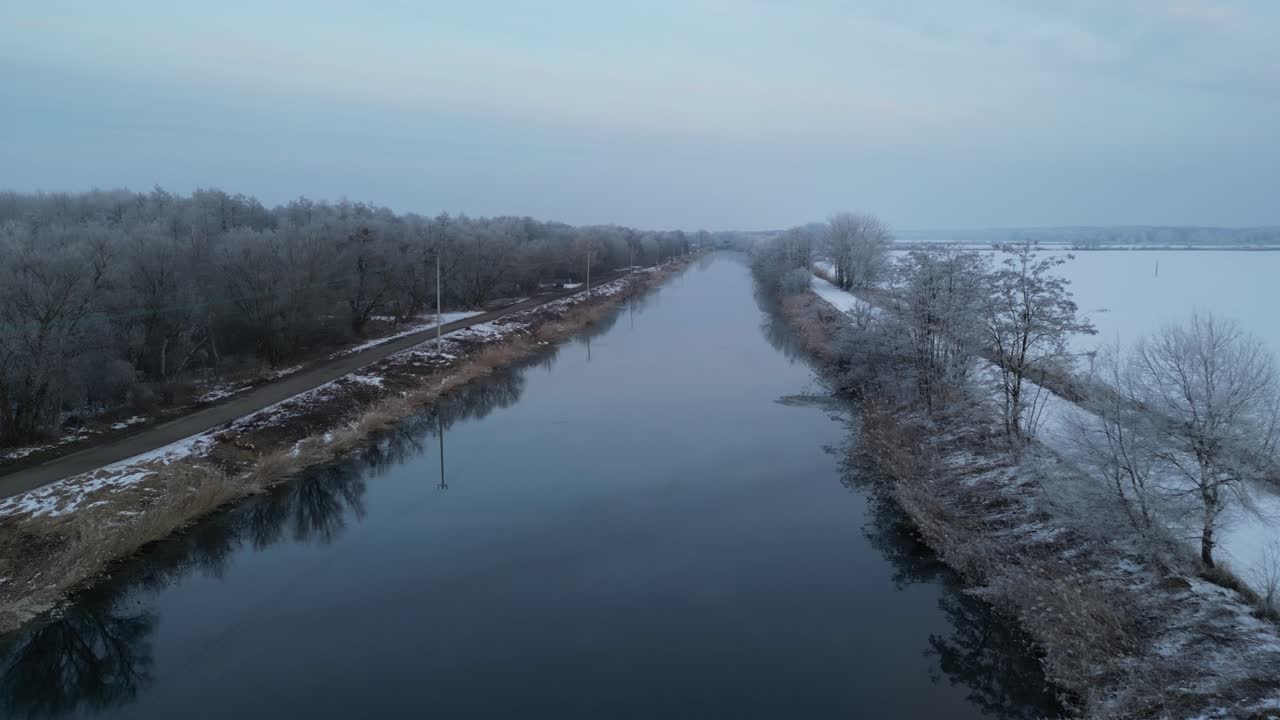 En 4K-drone følger den varme kanal langs Konin-området med frosne fiskedamme og sneklædte diger i nærheden. Optagelsen understreger den termiske vandkorridor, der skærer sig igennem et dybt vinterlandskab.