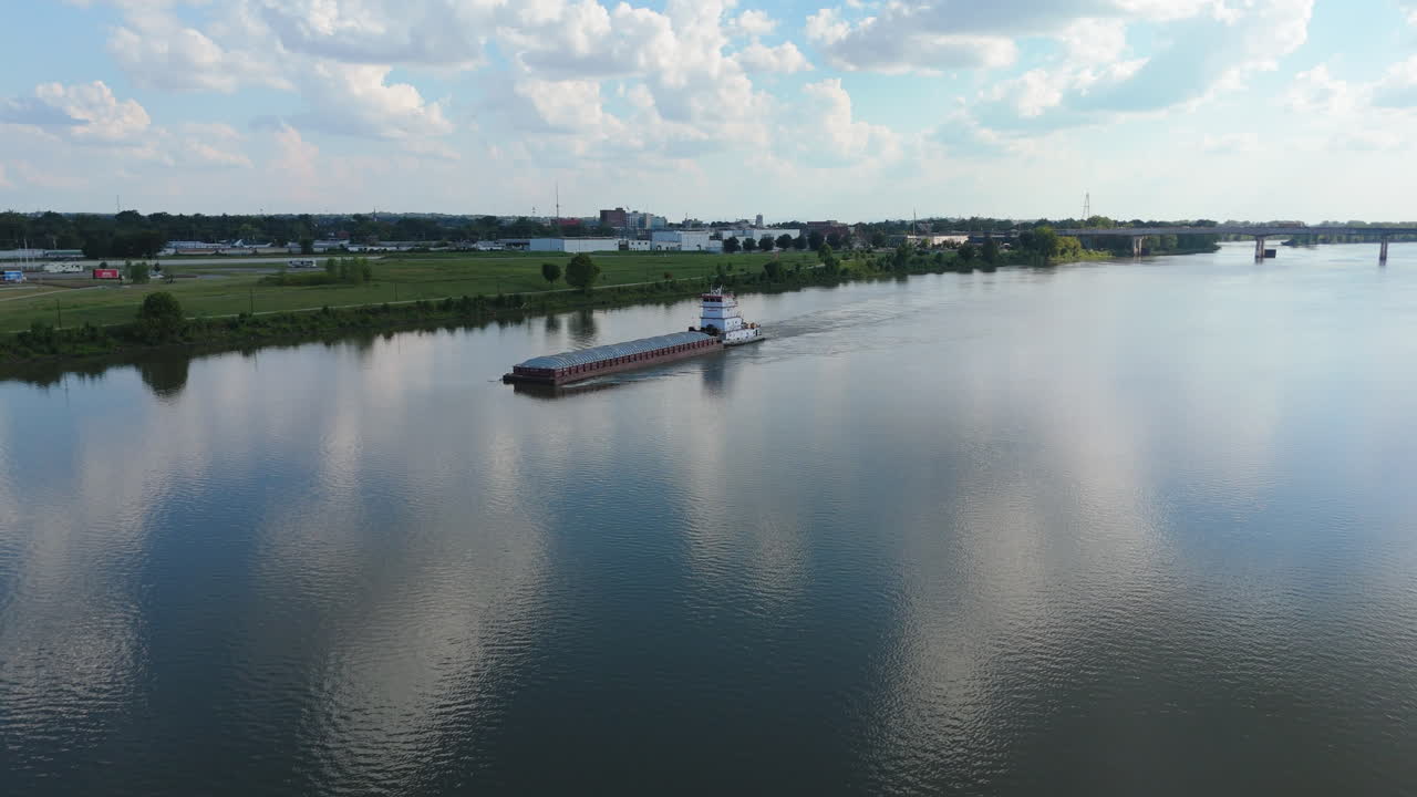 Drone aerial wide approach to barge on Arkansas River with clouds reflecting in smooth water