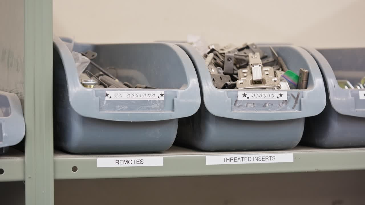Close pan highlights labeled tool bins and furniture repair parts in workshop