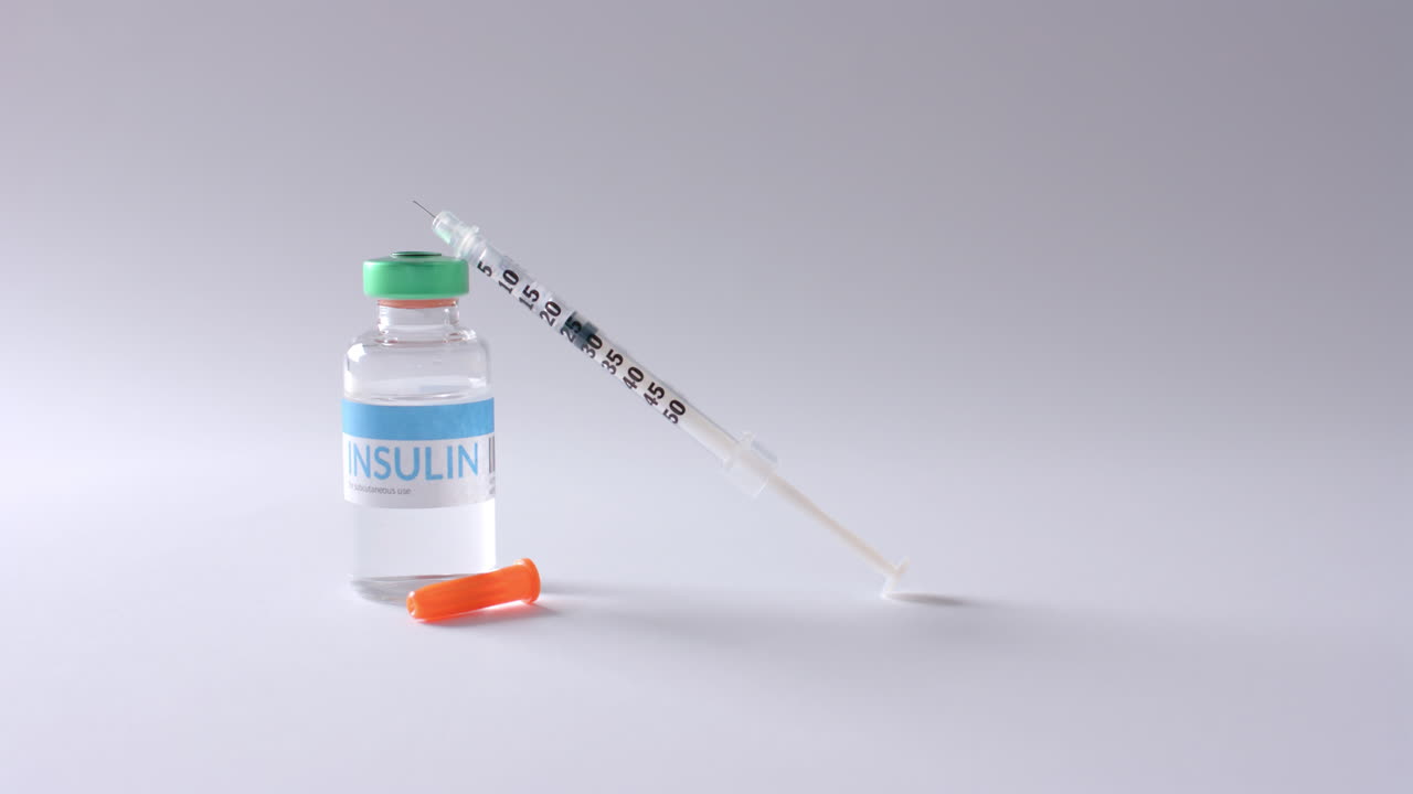 회색 바탕에 인린 병과 주사기의 가까운 모습, 느린 동작