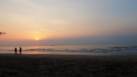 Imágenes-De-Lapso-De-Tiempo-De-Personas-En-Una-Hermosa-Playa-Tropical-Silueteada-Por-El-Amanecer