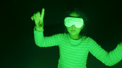 young girl wearing fake virtual reality headset under green lighting