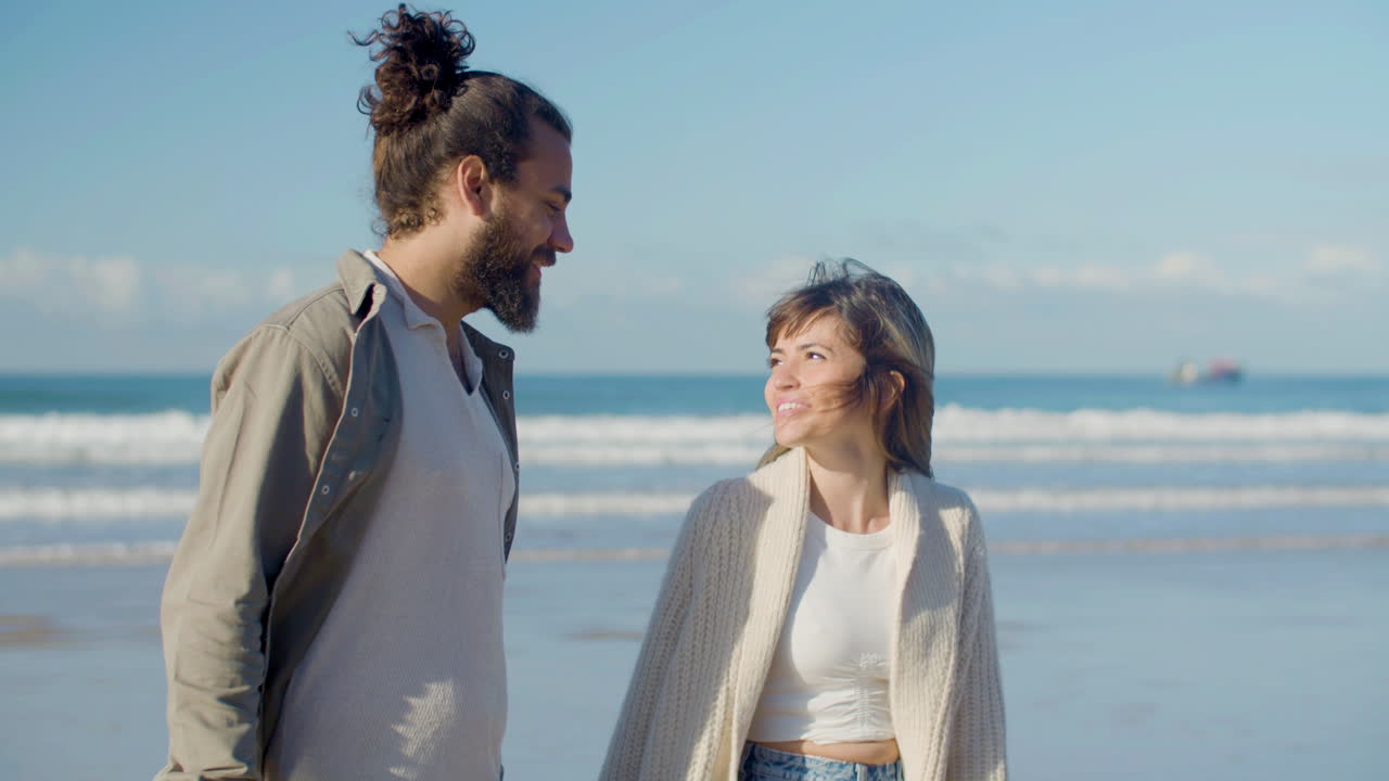 아름다운 백인 부부 가 해변 을 따라 산책 하고 있다